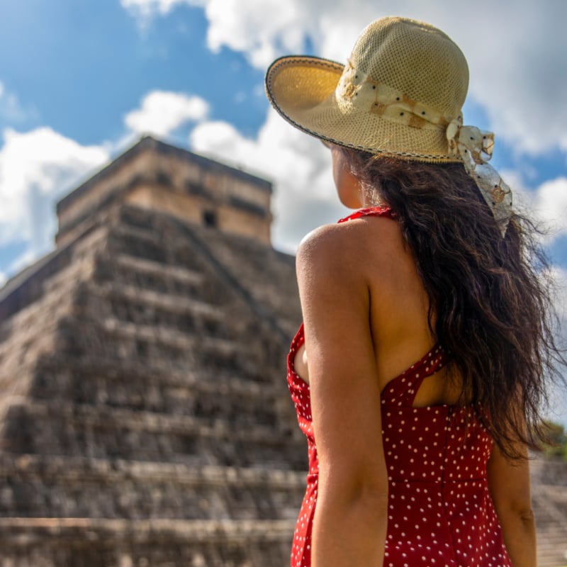 Woman tourist observing the old pyramid and temple of the castle of the Mayan architecture known as Chichen Itza copy