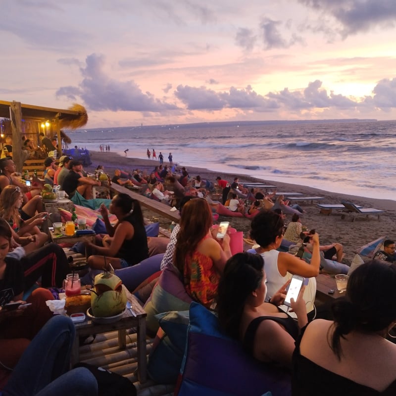 travelers gathered to admire the sunset on the beach in Bali