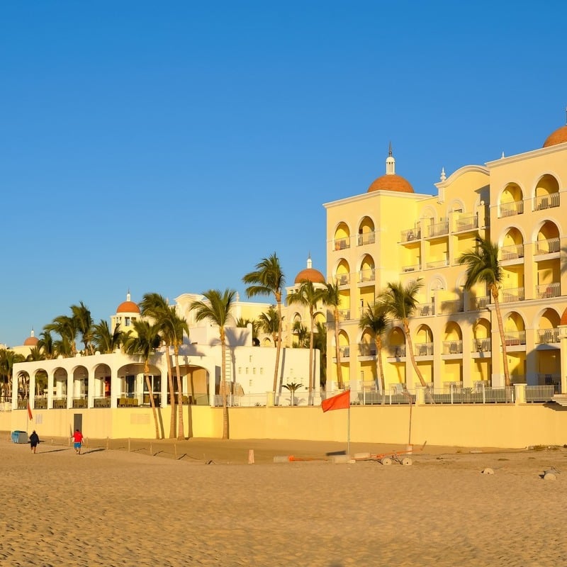 A sandy beach lined with resorts in Los Cabos, Mexico