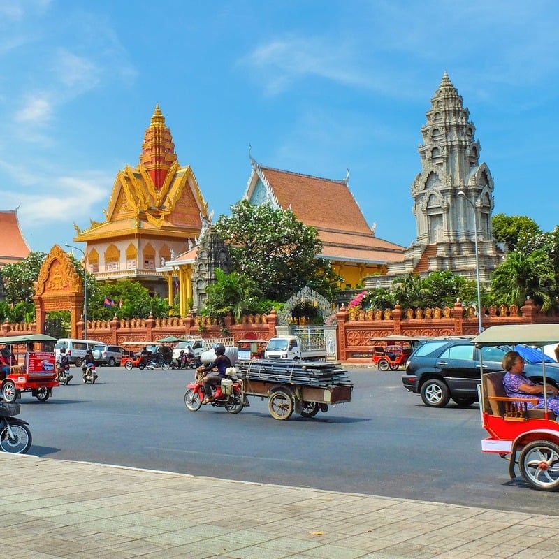 A busy road and ancient temples in Phnom Penh, the capital city of Cambodia, Southeast Asia