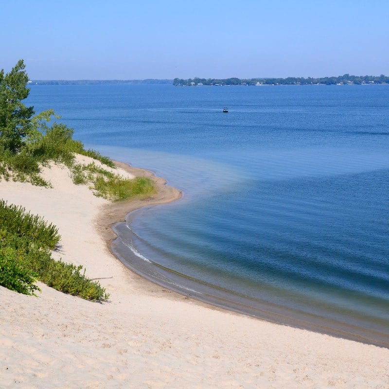 Sand dunes meeting the blue water of Lake Ontario in Prince Edward County