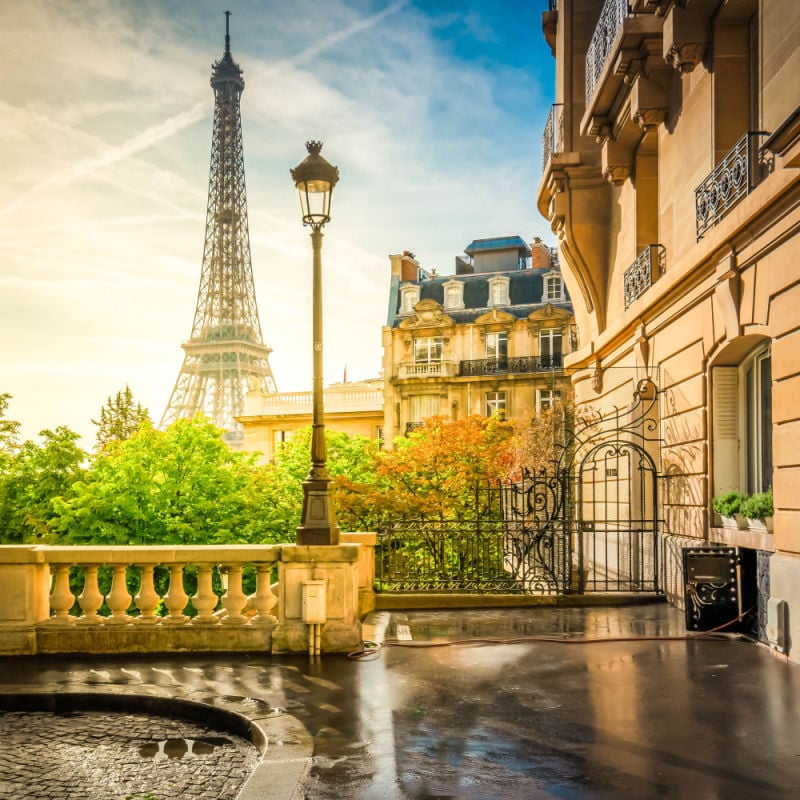 A street view of Paris with the Eiffel Tower in the background. 