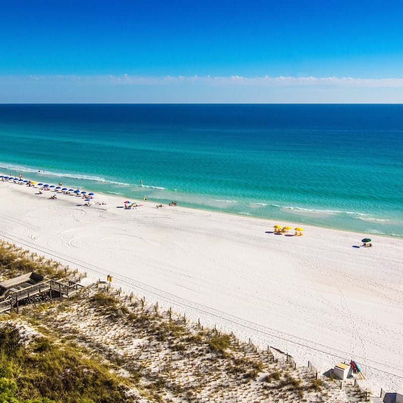 Destin, Florida - October 24, 2014: Beach goers enjoy the white sand beaches and emerald blue waters of the Panhandle in Destin, Florida.  Originally as a small fishing village, it is now a popular tourist destination.