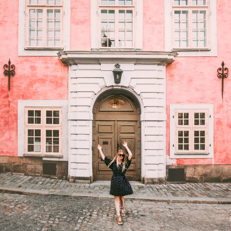 Happy woman walking in Stockholm travel sightseeing architecture landmarks lifestyle summer vacations tour in Sweden