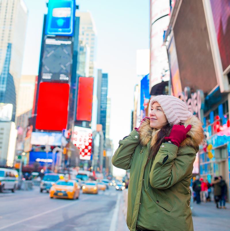 Young woman wearing a winter coat in times square new york city