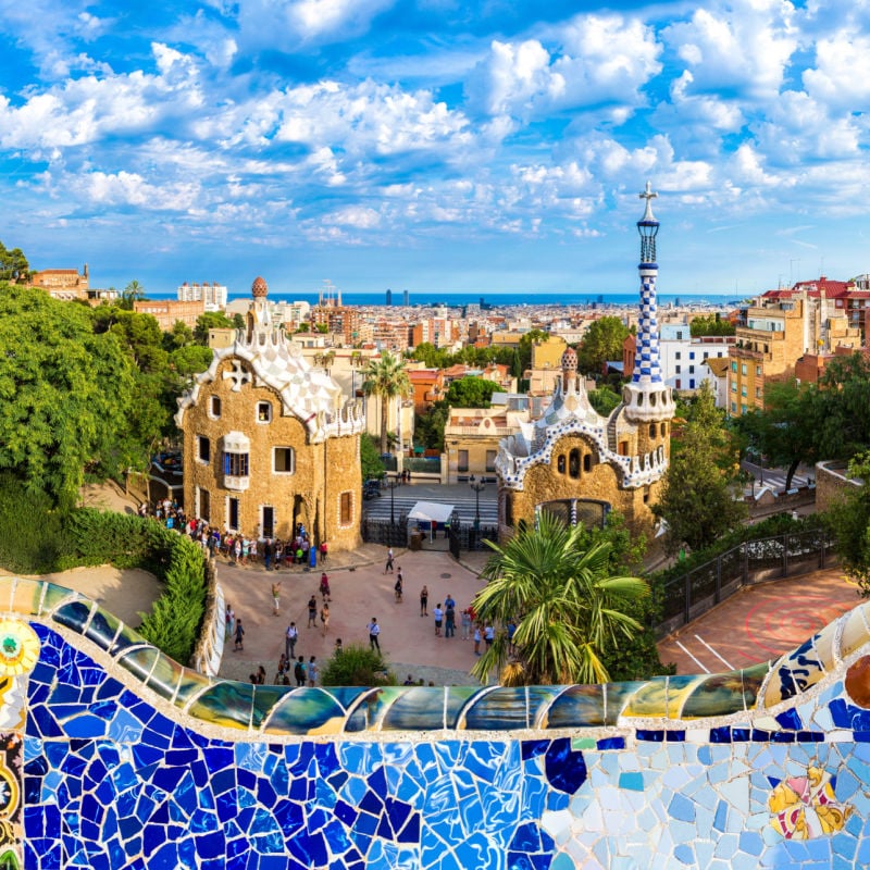 view over barcelona from park guell with colorful mosaics in the foreground